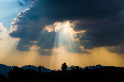 Low angle view of silhouette mountains against dramatic sky