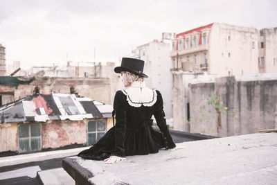 Full length of woman standing in front of city