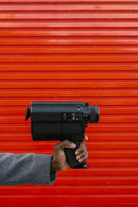 Close-up of man photographing with red camera