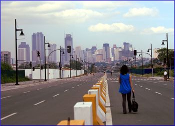 Rear view of woman walking on city street