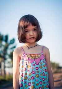 Portrait of cute girl standing against sky