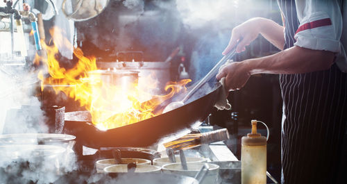 Chef stir fry busy cooking in kitchen. chef stir fry the food in a frying pan