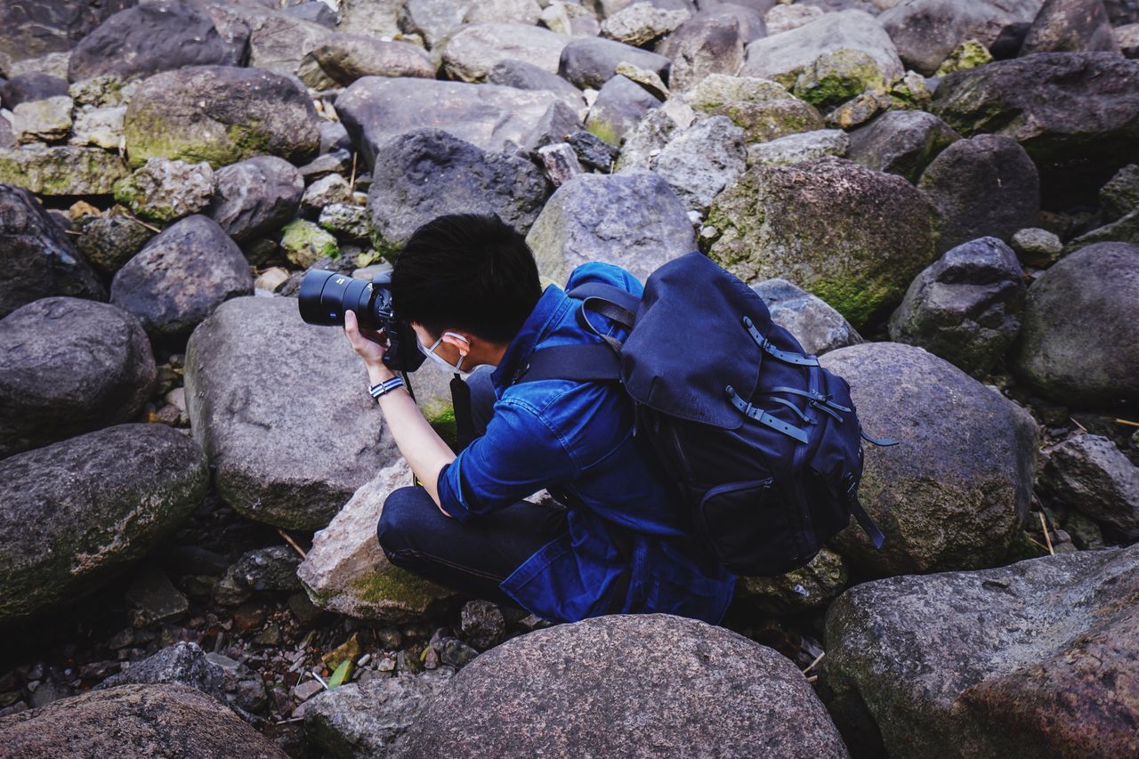 rock - object, stone - object, rock, lifestyles, leisure activity, rock formation, stone, nature, high angle view, men, day, pebble, outdoors, standing, full length, beauty in nature, tranquility, sunlight