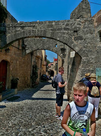 Rear view of people on cobblestone street