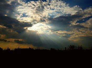 Silhouette of trees against dramatic sky during sunset