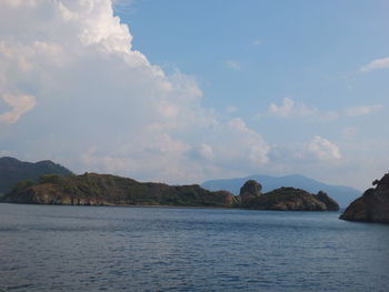 Scenic view of sea and mountains against sky