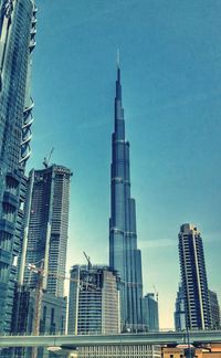 Low angle view of skyscrapers against blue sky