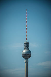 Low angle view of fernsehturm against blue sky in city