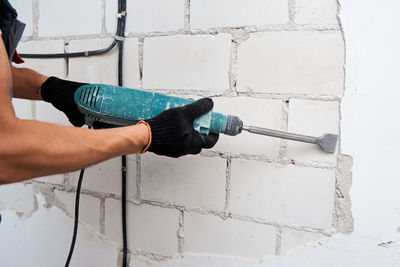 Midsection of man working on wall