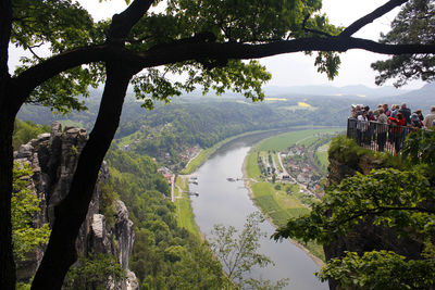 People by railing over river