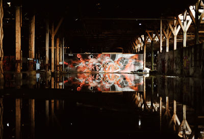 Reflection of people in illuminated glass at night