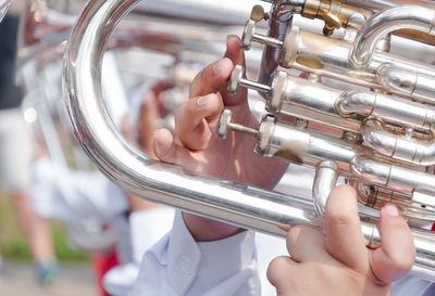 Cropped hands of man playing wind instrument during event