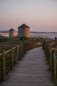 Pier over sea against sky during sunset