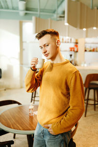Young man drinking coffee cup on table