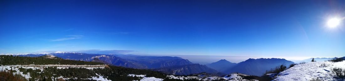 Scenic view of snowcapped mountains against blue sky