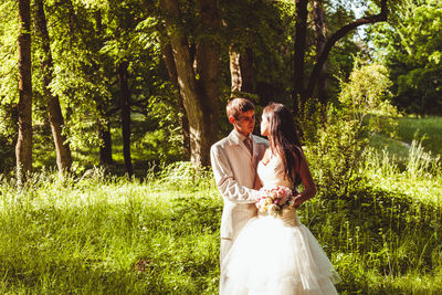 Couple kissing on plants against trees