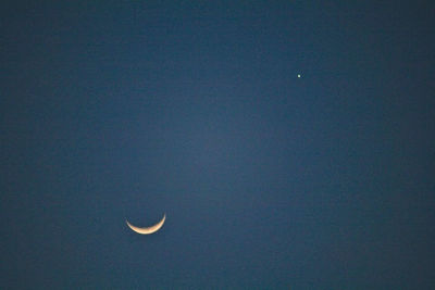 Low angle view of moon against blue sky