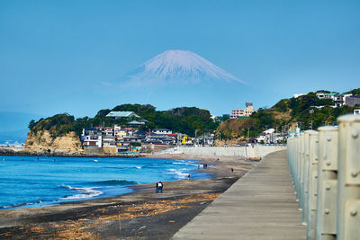 Panoramic view of sea and buildings against blue sky