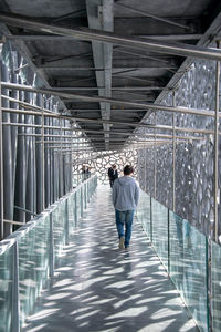 Rear view of man walking on walkway