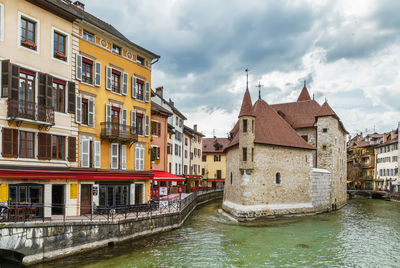 Canal amidst buildings against sky