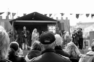 People watching medieval stage performance on street