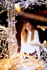 Young woman looking at illuminated lights during christmas