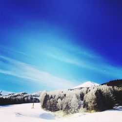 Scenic view of snowcapped mountains against blue sky