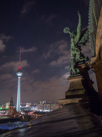 Illuminated tower in city against sky at night