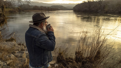 Hiker man enjoys beautiful natural scenery with a cup of hot drink. man drinking coffee 