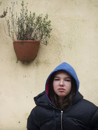 Portrait of beautiful woman standing against wall