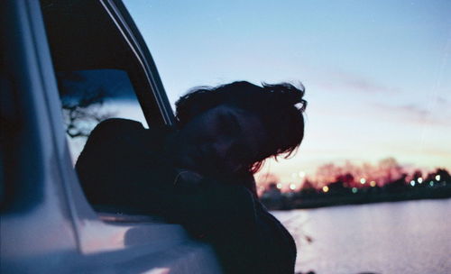 Side view of man with dog in car