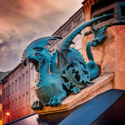 Low angle view of dragon-statue against blue sky