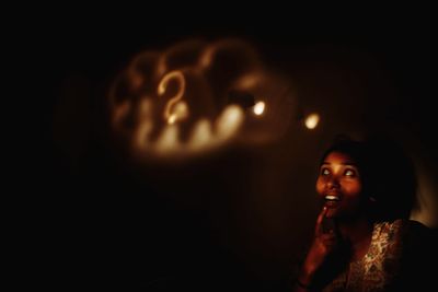 Portrait of young woman in dark room