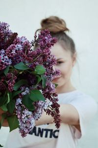 Portrait of woman by purple flowering plant