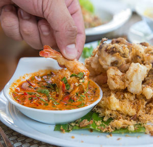 Close-up of hand holding food on table