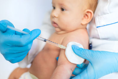 Doctor giving vaccination to baby at clinic