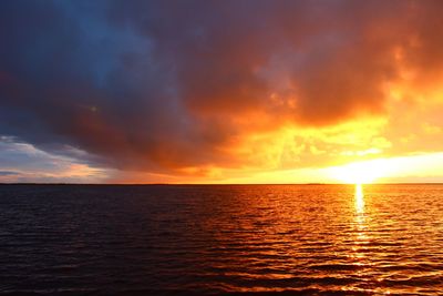 Scenic view of sea against dramatic sky during sunset