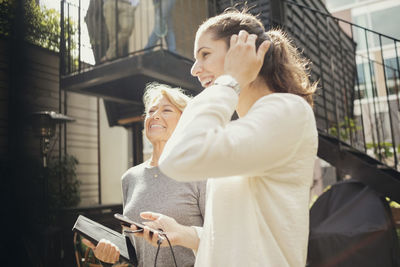 Happy businesswomen standing at office yard on sunny day