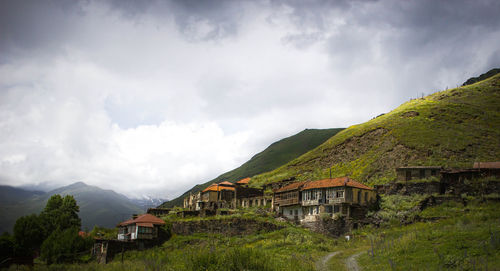 Panoramic shot of cottage amidst buildings against sky