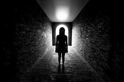 Full length of silhouette woman standing in tunnel