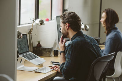 Business people working on desktop computers at table in office