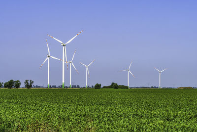Wind turbines green energy in the farmland with a clear blue sky