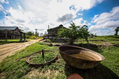 Abandoned car on field against sky