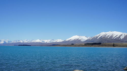 Scenic view of snowcapped mountains against clear blue sky