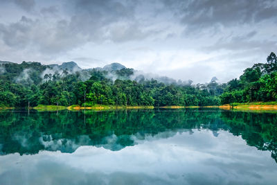 Scenic view of lake by trees against sky