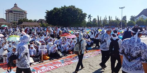 People on street in city against sky