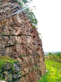 Low angle view of rocks on field against clear sky