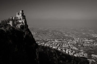 Castle at monte titano against sky on sunny day in town