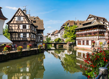 Buildings by river against built structures