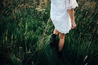 Low section of woman walking on field